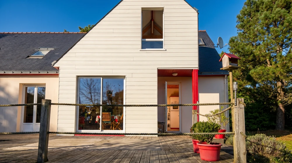 Extension contemporaine d'une maison individuelle, vue extérieure sur terrasse carrelée