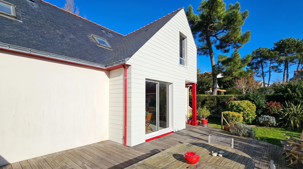 Maison contemporaine à toit de chaume, façade blanche