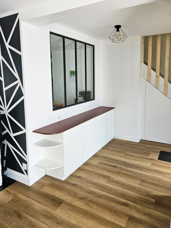 Photographie d'un intérieur résidentiel en cours de rénovation énergétique, montrant l'installation de panneaux isolants ou de matériaux d'isolation thermique sur une paroi intérieure ou sous un plafond. L'image doit clairement montrer le travail d'isolation (mousse, laine minérale, ou panneaux isolants visibles) avec un environnement domestique reconnaissable, illustrant concrètement l'amélioration des performances thermiques d'une habitation.